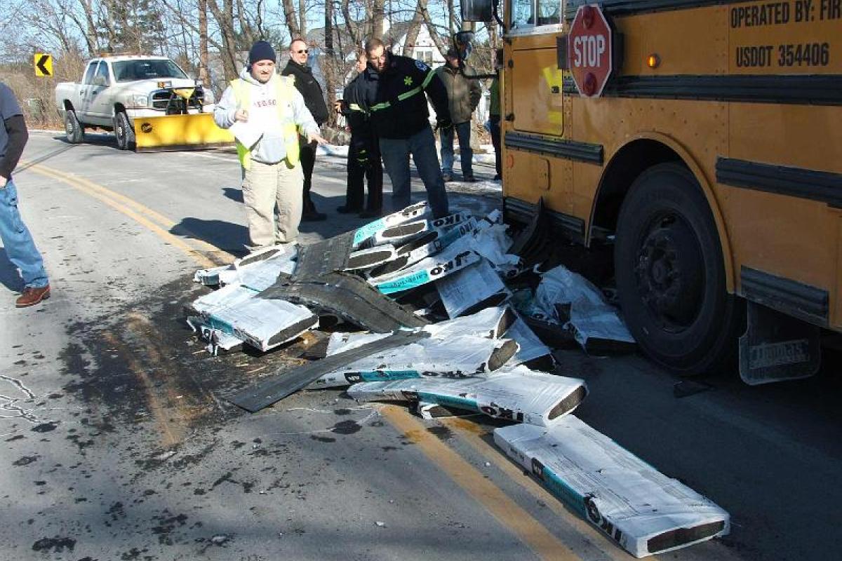 Bus accident, roofing shingles slide off a truck and struck the bus. 