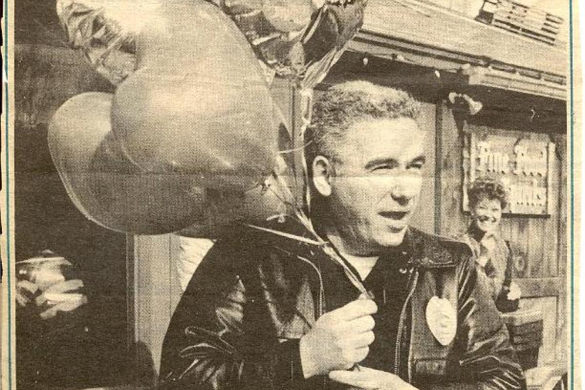 Newspaper photo of officer with balloons