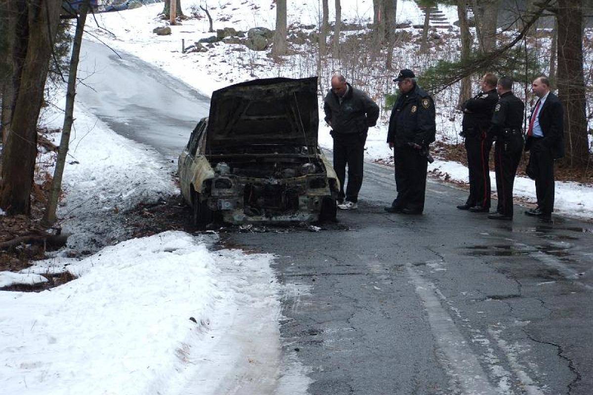 Torched get away vehicle from a Stratham bank Robbery, on scene is Greenland Fire Chief Ralph Cresta, Stratham Chief Michael Dal